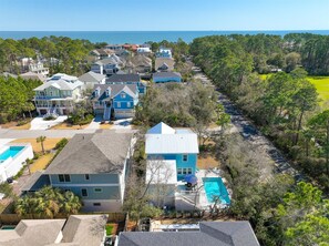 Un quartier résidentiel avec des maisons, une piscine et une route.