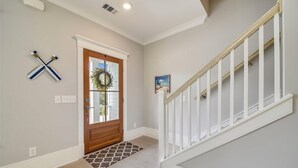 A hallway with a wooden door, a white railing, and a patterned rug. - 1 Shore Crest, Large Pool, Ping Pong, Beach, Free Golf, Outdoor Kitchen (Hilton Head)