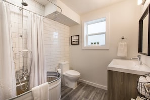 Un baño moderno con ducha, inodoro y lavamanos.