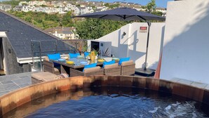 Un espace piscine aménagé sur le toit, avec un coin repas et une vue sur le quartier.