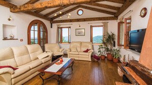 A spacious living room with wooden beams, a large TV, and multiple seating areas. - Holiday home with pool, sauna and gym (Opatija)