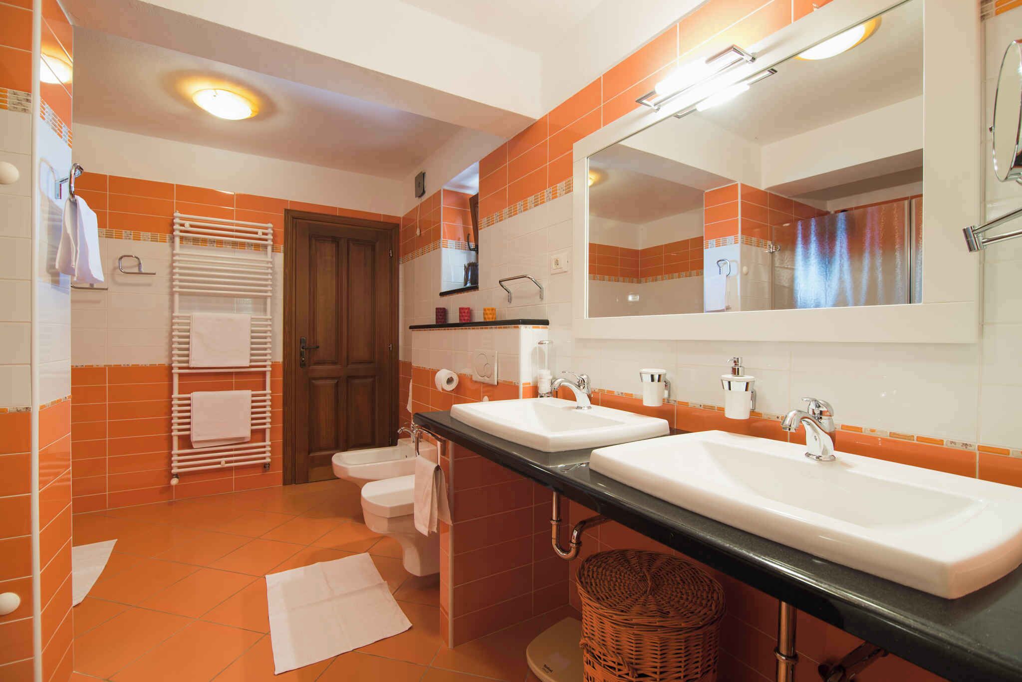 A bathroom with two sinks, a toilet, a towel rack, and a mirror.