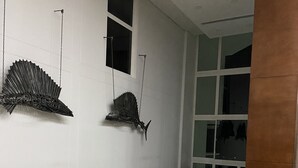 Una sala de estar moderna con muebles de mimbre, un sofá blanco y decoración en la pared.