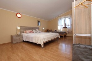 Une chambre à coucher comprenant un lit, des tables de chevet, un bureau et une armoire.
