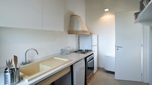 A compact kitchen with a sink, stove, and oven. - Nice apartment with private terrace. Shared pool. In Donnafugata, Sicily (Donnafugata)