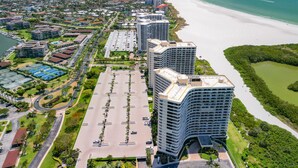 A high-rise hotel with a curved facade, adjacent to a beach and a marina. - Beach Front Condo in Paradise Marco Island (Marco Island)
