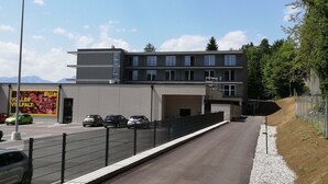 En moderne bygning med flere etager og en parkeringsplads foran.