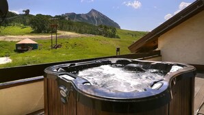 Un jacuzzi sur un balcon avec vue sur les montagnes.
