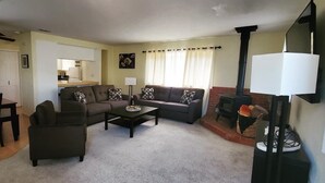 A living room with a sofa set, a coffee table, a TV, and a fireplace. - Woodland Pines Cabin (Frazier Park)