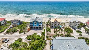 A coastal property with multiple buildings, a beach, and a view of the ocean.