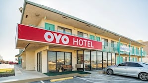 A hotel named OYO with a red and white sign, a parking lot, and a wheelchair-accessible ramp. - OYO Hotel Oklahoma City Northeast (Oklahoma City)