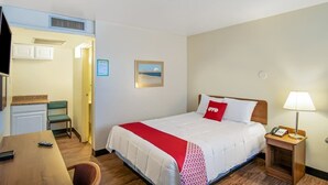 A hotel room with a bed, a desk, a chair, a lamp, and a picture on the wall. - OYO Hotel Oklahoma City Northeast (Oklahoma City)