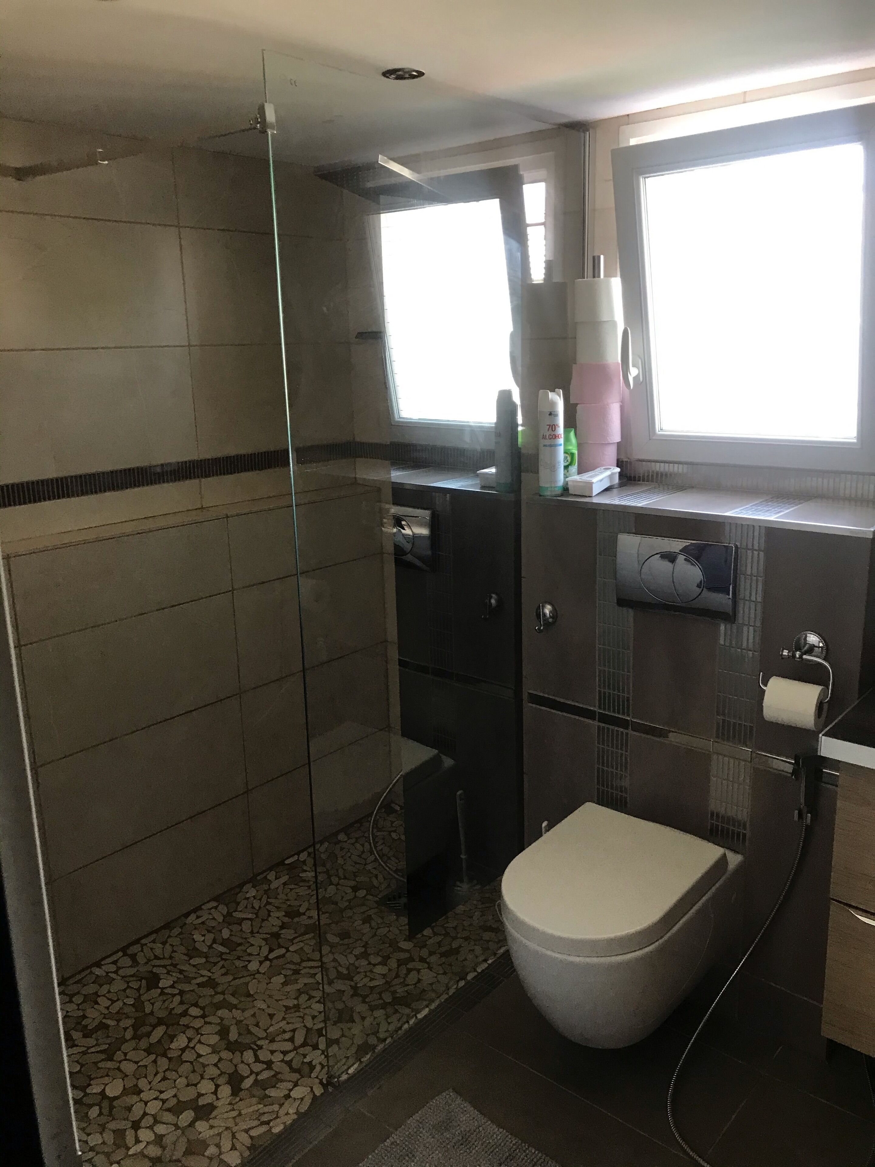 Ein modernes Badezimmer mit einer Duschkabine, einer Toilette und einem Waschbecken.