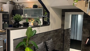 A modern kitchen with a black countertop, a built-in oven, and a hanging plant. - House with swimming pool facing south close to all shops  (Le Pontet)