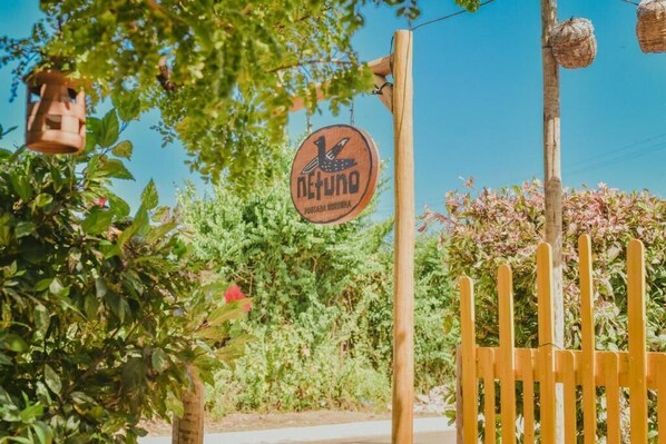 Une porte en bois sur laquelle est apposée une enseigne indiquant « netuna » et un logo représentant un oiseau.
