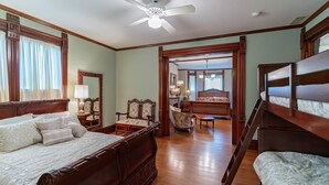 A spacious bedroom with a large bed, a chair, and a desk.
