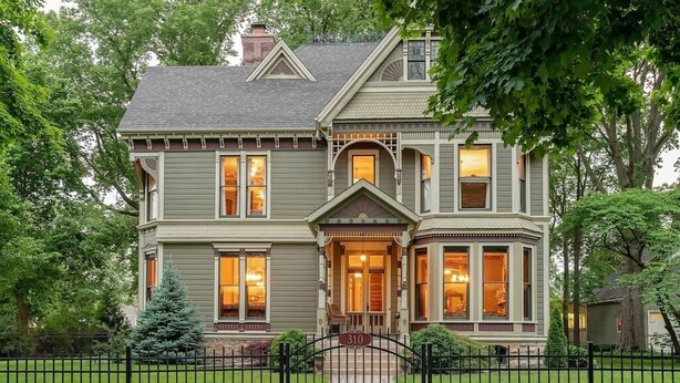 A two-story Victorian-style house with a prominent bay window and a front porch.