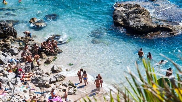A beach with clear blue water, rocky shore, and people enjoying the sun. - Charming tourist apartment (Bagheria)