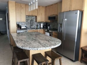 Enjoy cooking in this well-equipped kitchen with a central island, sink, and oven.