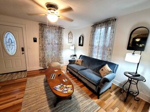 A living room with a sofa, coffee table, and a ceiling fan.