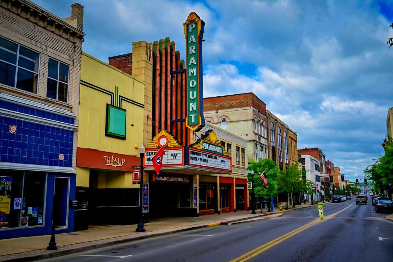 A street with a Paramount theater, a TRIPSUP store, and other buildings.