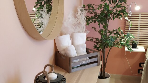 A neatly arranged room with a wooden desk, a mirror, a potted plant, a small table with a candle, and a lamp. - Spacious apartment near the beaches and at the foot of Mount Etna (Mascali)
