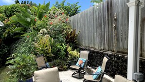 A patio with outdoor furniture and lush tropical plants. - Beautiful home in Kailua-Kona with easy access to all the Island. (KAILUA KONA)