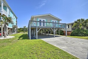 Une maison à deux étages avec un patio couvert et un garage.