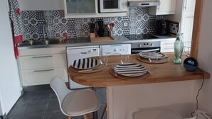 Una cocina moderna con armarios blancos, un microondas, una estufa y una encimera de madera.