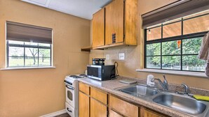 Una cocina con armarios de madera, estufa, microondas y lavaplatos.