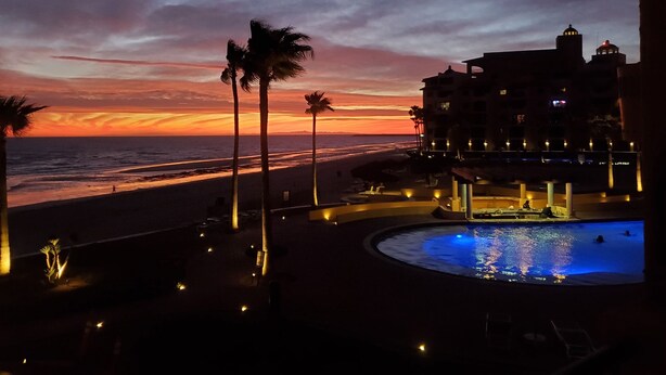 Un complexe hôtelier doté d’une piscine, d’une plage et offrant une vue sur le coucher de soleil.