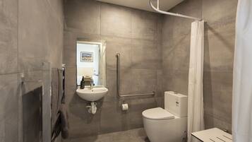Un baño moderno con inodoro, lavamanos y ducha.