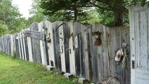 A rustic wooden fence with various items attached, including lanterns and a basket. - Relax at the historic Austin House (Addison)