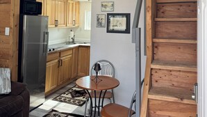 Un interior de madera con cocina, comedor y escalera.
