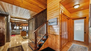 A wooden interior with a staircase, a kitchen area, and a bathroom. - Bishop | Amazing location on Rangeley Lake and close to downtown (Rangeley)