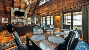 A wooden interior with a stone fireplace, a television mounted above it, and a sign reading "RANGELEY". - Bishop | Amazing location on Rangeley Lake and close to downtown (Rangeley)