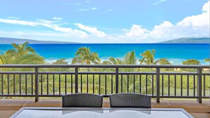 Ein Balkon mit Blick auf das Meer und Palmen.