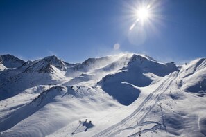 A snow-covered mountain landscape with ski slopes and ski lifts.