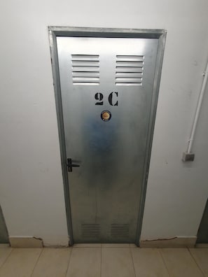 A metallic door with ventilation slits, a circular logo, and a number '20' on it.