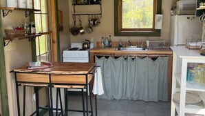 A compact kitchen with wooden cabinets, a countertop, and a window. - 540-acre farm with trails, creeks, animals & nearby attractions (Irvine)