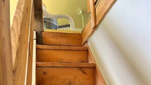 A wooden staircase with a white wall on one side. - 540-acre farm with trails, creeks, animals & nearby attractions (Irvine)