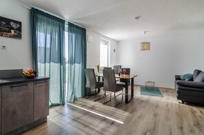 Una sala moderna con comedor, un sofá y una encimera de cocina.