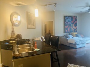 Cozy retreat with a kitchenette, comfortable bed, and a wall-mounted mirror.