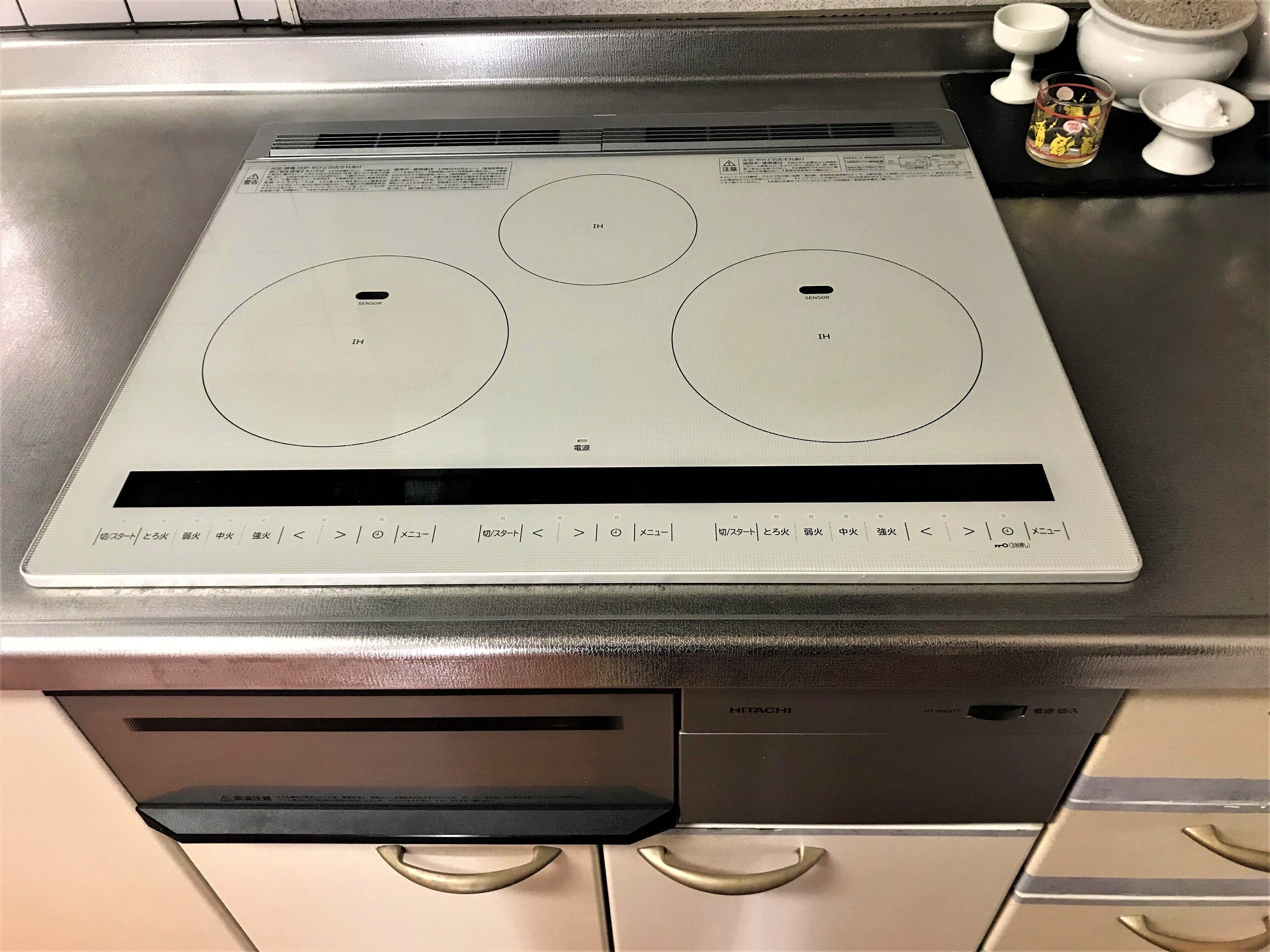 A kitchen with a built-in induction cooktop, a dishwasher, and a sink.