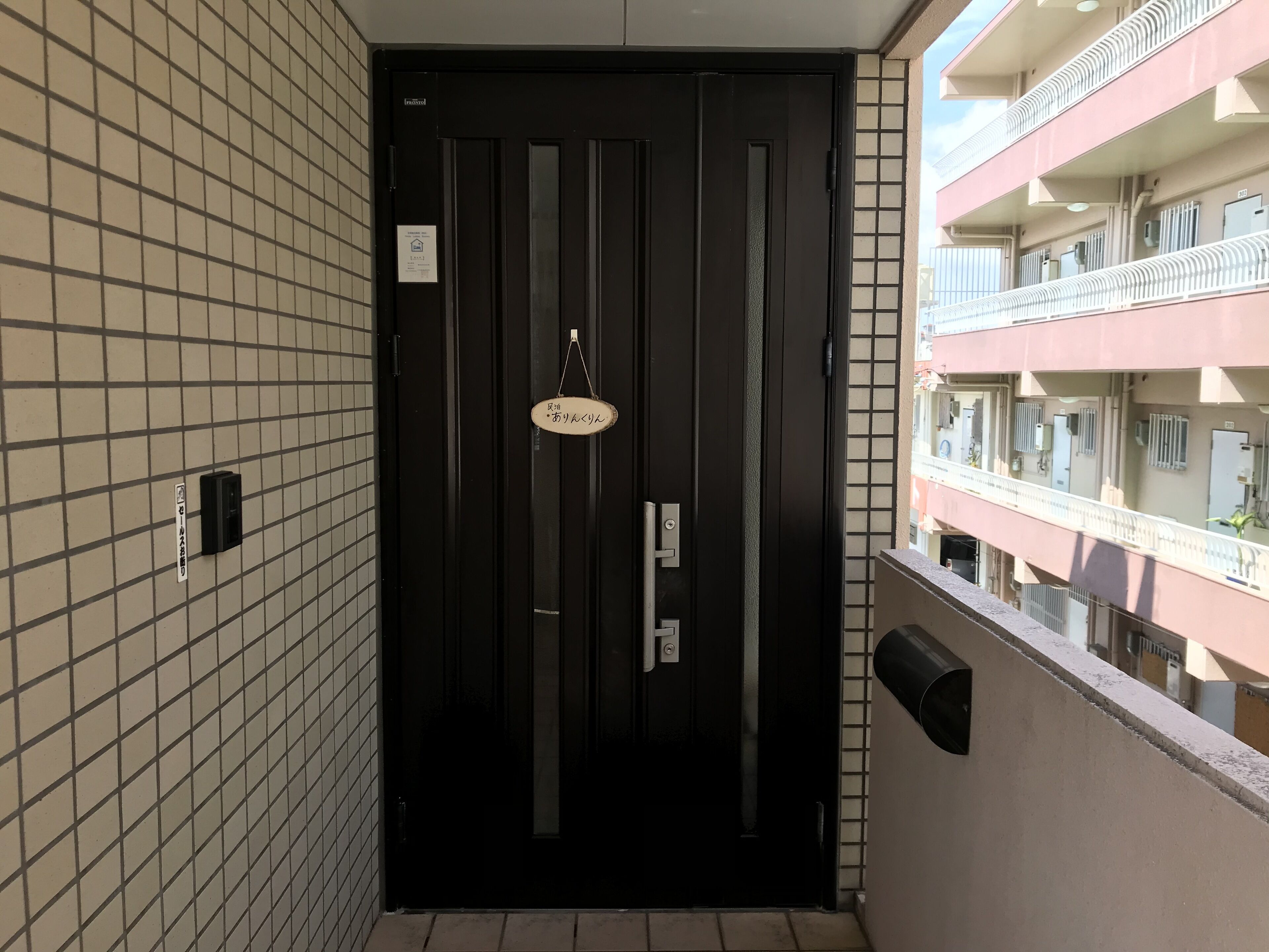 Una puerta negra con un letrero que dice "Ryo's" y una pequeña placa colgante.