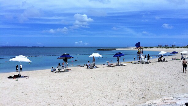 A beach with umbrellas and people. - Minpaku Arin Kurin (Haebaru)