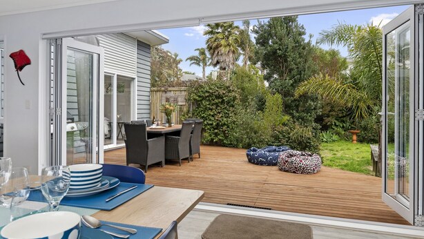A patio with a dining table, chairs, and bean bags. - Pohutukawa Peace - Mangawhai Holiday Home (Mangawhai Village)