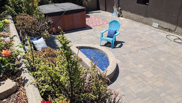A patio area with a fire pit, a blue chair, and various plants. - Bay views, easy access to beaches and downtown. Relax in your own hot tub!!! (San Diego)