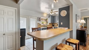 A kitchen with a central island, wooden chairs, a ceiling fan, and a clock on the wall. - Bay views, easy access to beaches and downtown. Relax in your own hot tub!!! (San Diego)