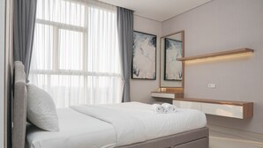 A modern bedroom with a bed, a bedside table, a mirror, and artwork on the wall.
